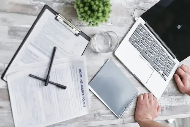 Escritorio con portátil, formularios y documentación personal