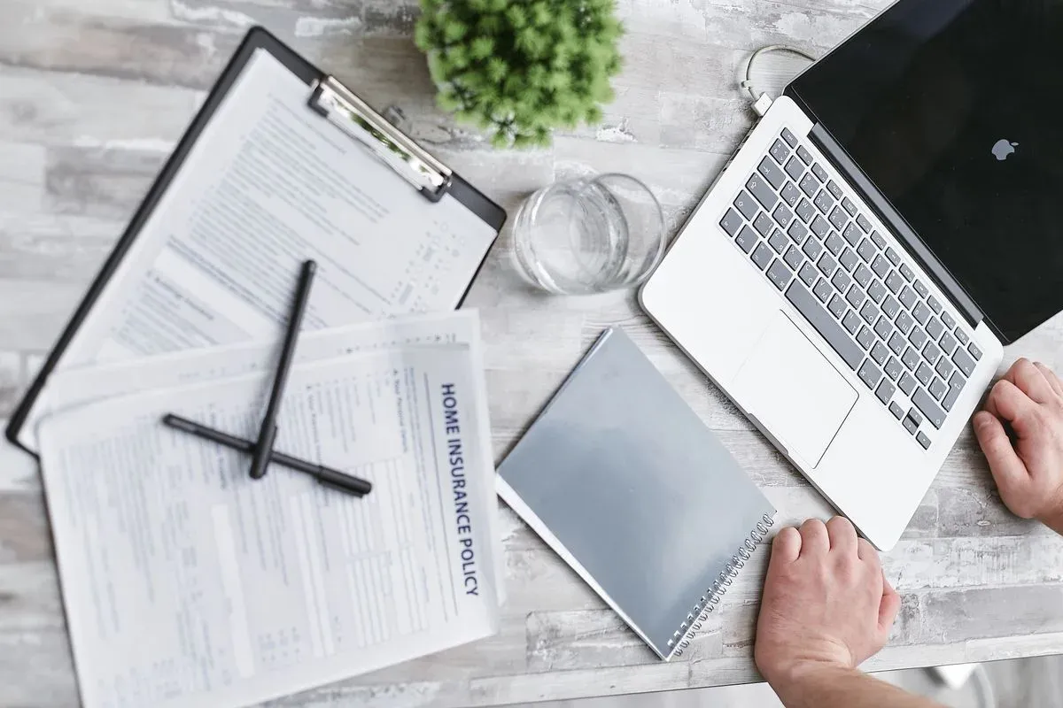 Escritorio con portátil, formularios y documentación personal